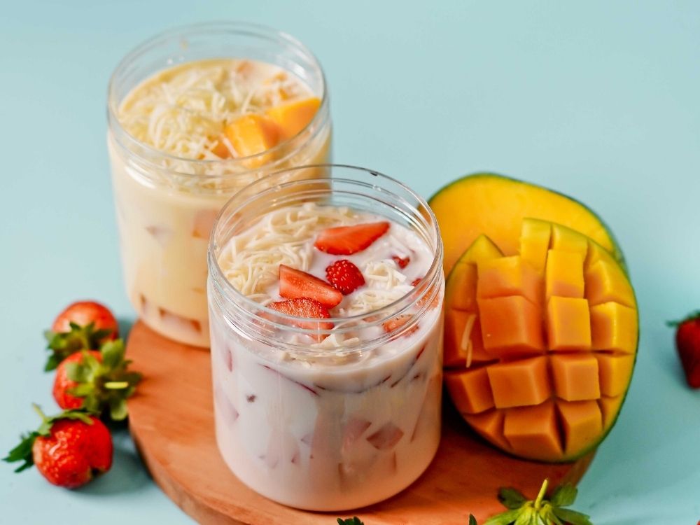 creamy fruit dessert with mango and strawberries in jars