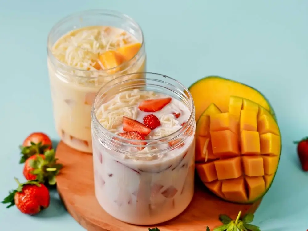 creamy fruit dessert with mango and strawberries in jars