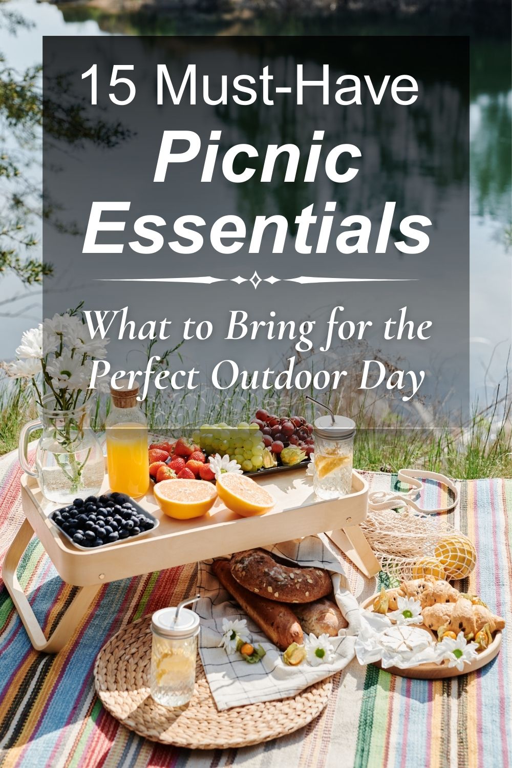 Picnic essentials laid out on a blanket by the lake with food, drinks, picnic tray, and outdoor setup